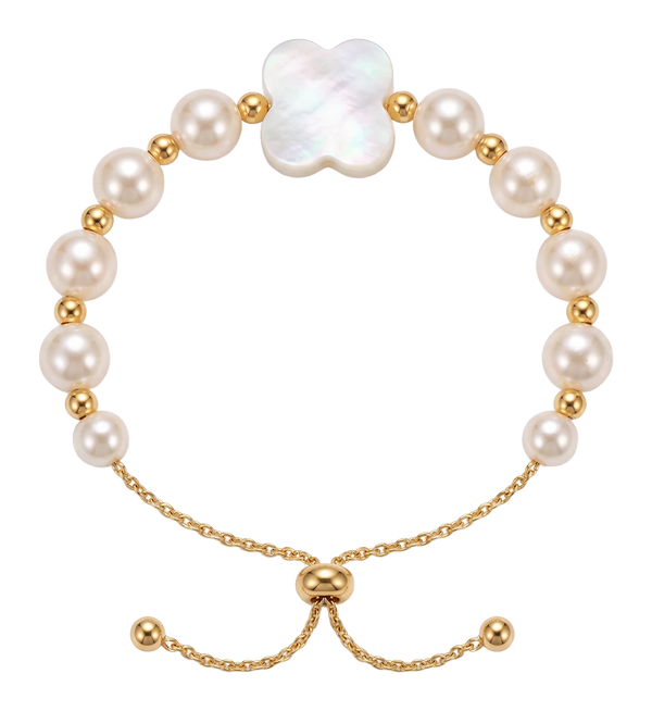 Bracciale di perle bianche con un fiore in madreperla a quattro petali, indossato al polso