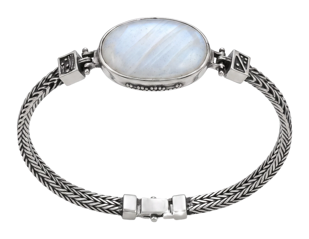 Bracciale in argento con grande cabochon ovale bianco e catena intrecciata, indossato al polso