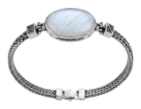 Bracciale in argento con grande cabochon ovale bianco e catena intrecciata, indossato al polso