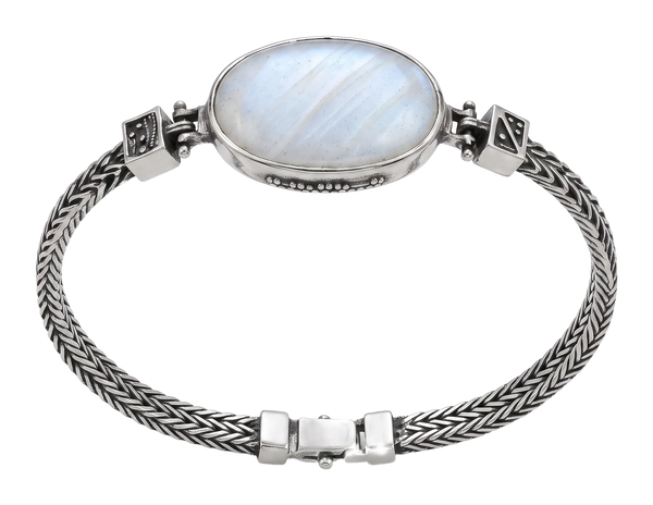 Bracciale in argento con grande cabochon ovale bianco e catena intrecciata, indossato al polso